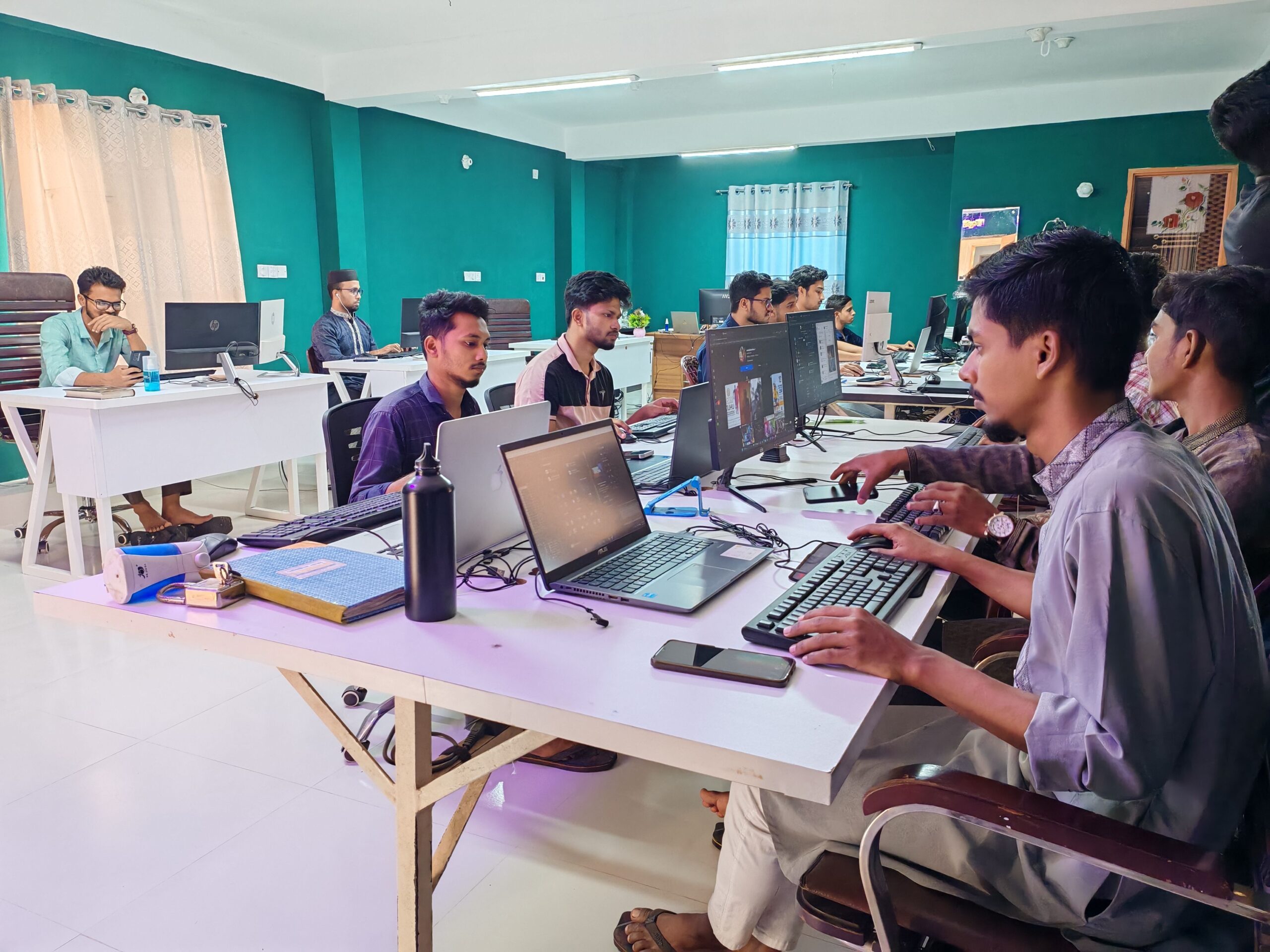 Software development team collaborating at computers in a modern office.